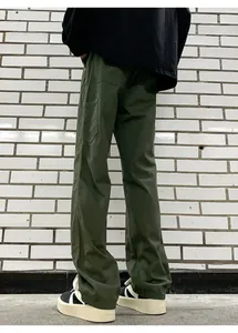 Macro detail of military green work pants showing large back pockets and topstitching