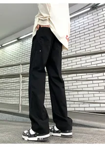 Low-angle view of black loose-fit cargo pants with stiff fabric and stylish drape