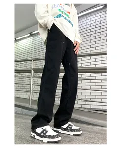 Detail view of black double-knee carpenter pants with metal rivets and straight leg cut