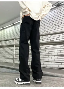 Detail of black double-knee work trousers showing side pockets and straight-leg fit