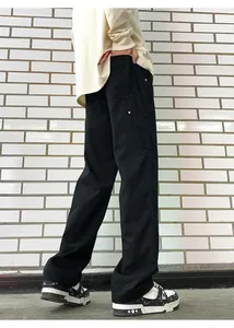 Detail of black baggy workwear pants showing the relaxed straight-leg fit and side profile