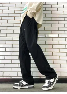 Detail of black double-knee carpenter pants with silver rivets and street style cut