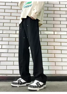Detail view of black men's carpenter pants with double knee rivets and loose straight fit