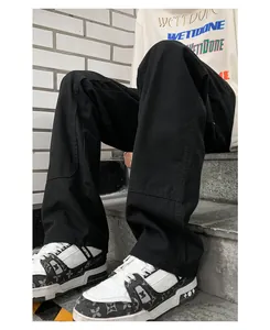 Detail of loose fit black workwear trousers with double knee seams in street style