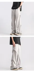 Detailed close-up of light gray pleated texture and drawstring waist on paratrooper pants