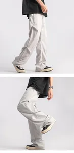 Macro detail of light grey paratrooper cargo pants with pleated texture and straight cut