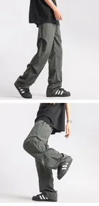 Detail view of dark grey parachute cargo pants featuring side stitching and pleated nylon fabric