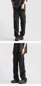 Detail of black parachute pants showing pleated fabric texture and drawstring waist