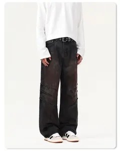 Dettaglio dei jeans neri a gamba larga con triple cuciture diagonali ed effetto invecchiato