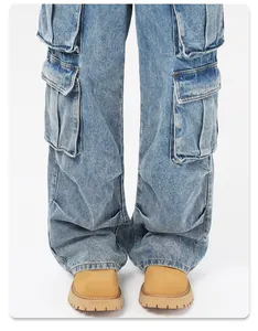 Gros plan sur la texture du denim délavé bleu et les détails multi-poches du pantalon