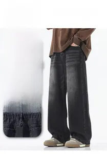 Detail of men's vintage washed denim pants showing elastic waistband and loose fit cut