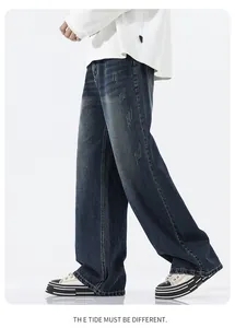 Detail view of deep blue wide-leg jeans with washed whiskers and distressed denim texture
