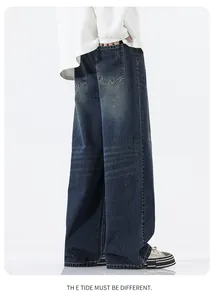 Detail of vintage blue wide-leg jeans with whiskering and faded wash effect on denim