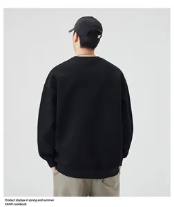 Rear view of black crewneck sweatshirt with dropped shoulders and a relaxed fit