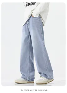 Detail of light blue straight denim jeans with vintage whiskering and relaxed cut