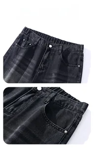 Detailed close-up of elastic waist and metal button on vintage wash black denim jeans