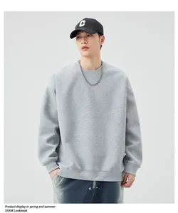 Detailed view of light grey sweatshirt texture with ribbed cuffs and loose shoulder seams