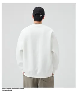 Detail view of the oversized white crewneck sweatshirt and premium ribbed cuff texture