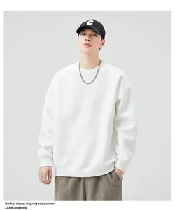Detail of a white crewneck sweatshirt with dropped shoulders and silver chain accessory