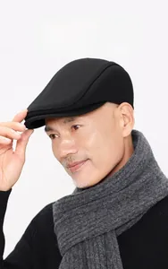 Detail view of the black woolen newsboy cap showing the warm textured fabric and ear protection