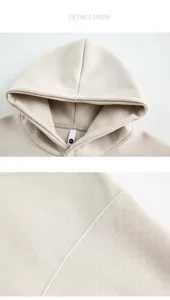 Details van de stiksels en neklabel op een beige zware kwaliteit hoodie shirt