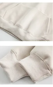 Detail view of the kangaroo pocket and ribbed cuffs on a heavy cotton hoodie