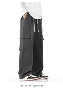 Détail du pantalon cargo gris foncé avec poches à rabat et cordon de serrage blanc
