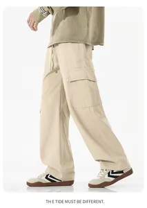 Détail d'un pantalon cargo beige avec de grandes poches utilitaires et une coupe droite