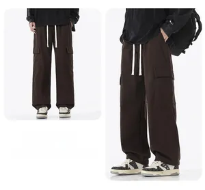 Détail du pantalon cargo marron foncé avec poches latérales à rabat et cordon blanc