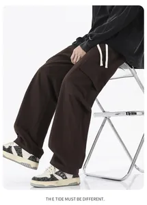 Détail du pantalon cargo marron avec grandes poches latérales et cordons blancs