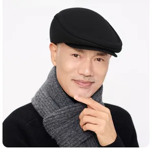 Classic black wool newsboy cap for men featuring fold-down ear flaps for winter warmth