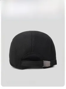 Detail of adjustable metal buckle and wool texture on black winter flat cap