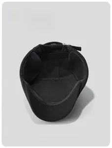Detail of warm black wool flat cap with thick fleece lining and adjustable metal buckle