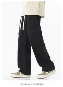 Détail du pantalon cargo noir avec poches latérales à rabat et cordon blanc cassé