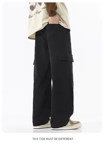 Détail d'un pantalon cargo noir avec de grandes poches à rabat et une coupe droite large