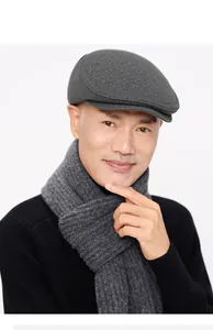 Detail of dark grey wool flat cap and knitted scarf for men in winter season