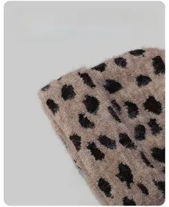 Close-up of leopard print knit beanie showing thick fleece lining and warm texture