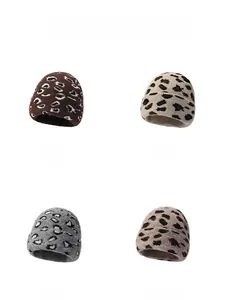 Detail showing four color variants of leopard print beanie hats with soft fuzzy texture