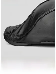 Detail of black faux leather flat cap featuring a wide brim and textured pleated design