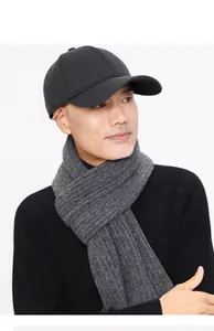 Detail of wool baseball cap with ear protection and ribbed knit scarf for winter warmth