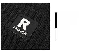 Detailed view of black knitted winter hat with ribbed texture and R-label patch