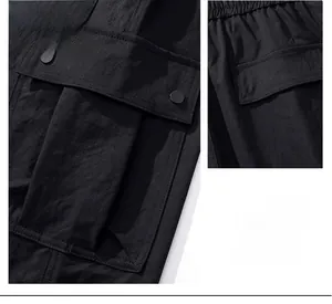 Detail of waterproof cargo pants featuring large side flap pockets and reinforced stitching
