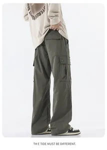 Detail of army green cargo pants featuring large flap pockets with metal buckles