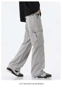 Detail view of light grey techwear cargo pants featuring large tactical flap pockets