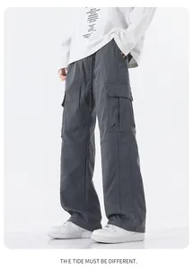 Detail view of charcoal grey waterproof cargo pants with side flap pockets and drawstrings