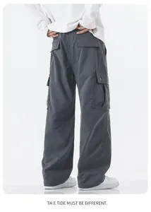 Detail view of men's dark grey waterproof cargo pants with large side pockets and loose fit