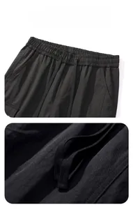 Detail view of the elastic waistband and drawstring on black tactical outdoor pants