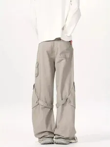 Men's grey wide-leg cargo pants with multi-pocket design and ribbon detailing from the back