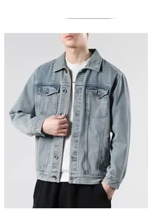 Detail of light blue washed denim jacket with metal buttons and chest flap pockets