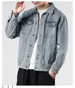 Detail of light blue washed denim jacket featuring classic button closure and chest pockets